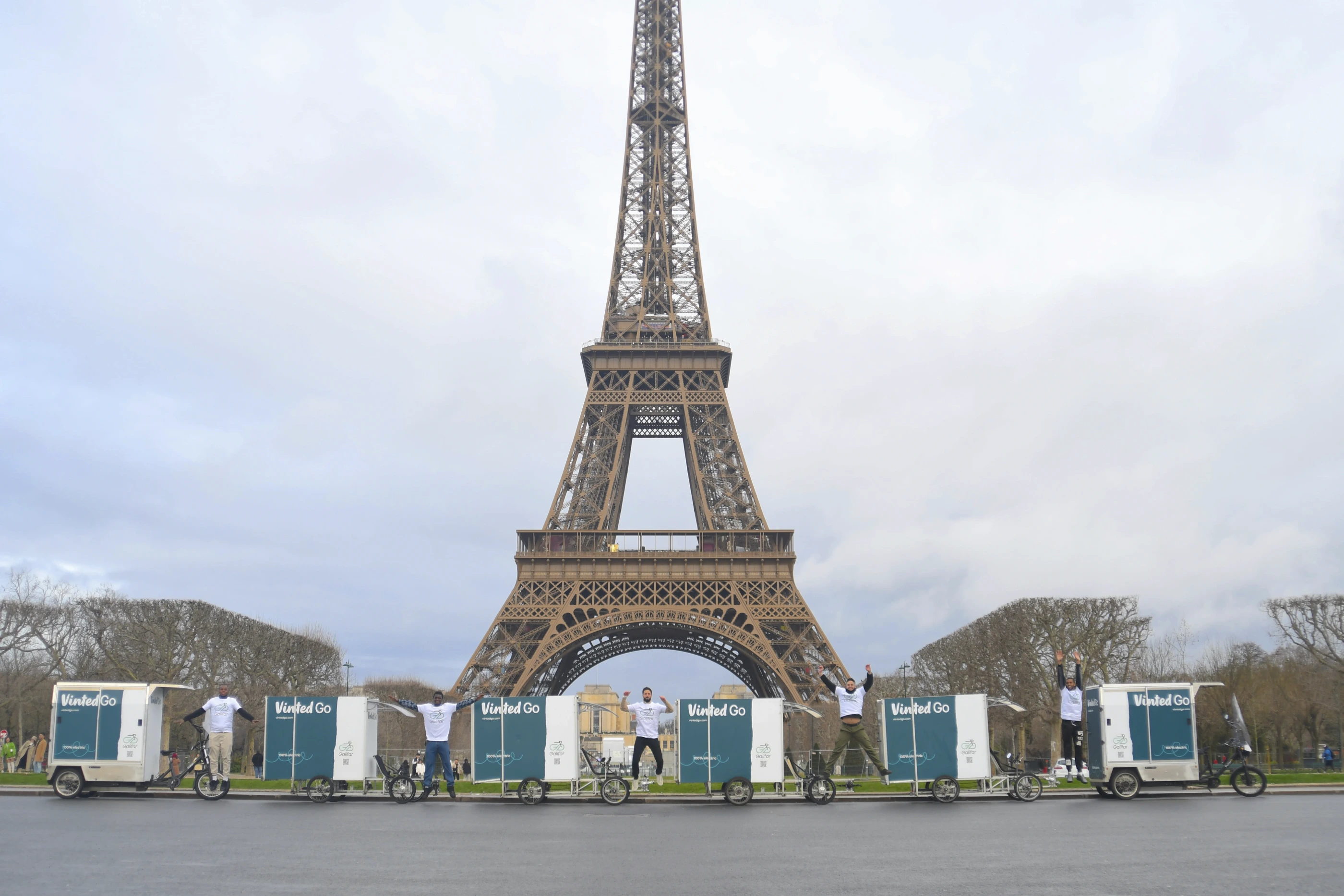 L'équipe Galifar saute devant la Tour Eiffel avec un convoi de vélos cargos Vinted Go