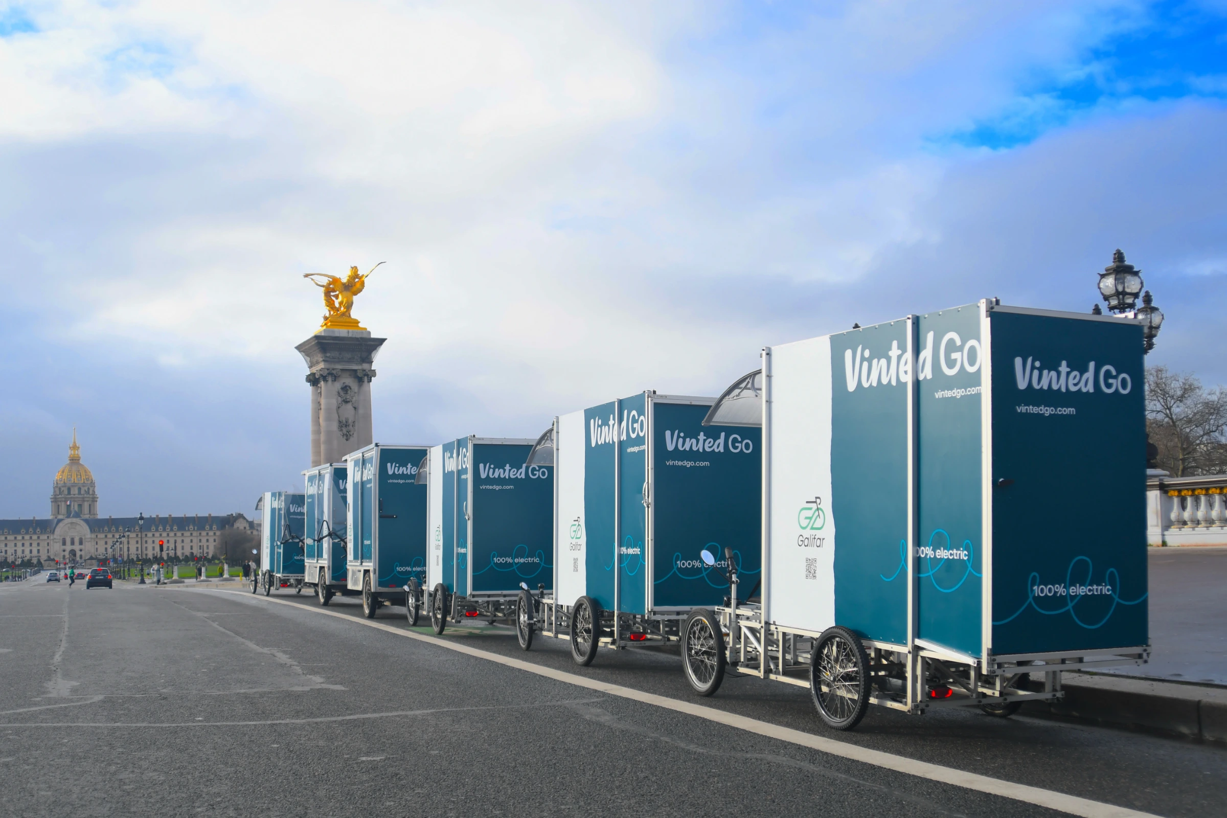 Convoi de vélos cargos Galifar × Vinted Go sur le Pont Alexandre III, statue dorée et dôme des Invalides en arrière-plan